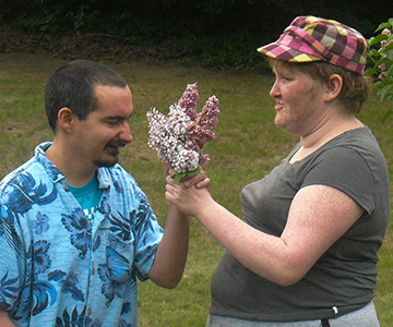 Young woman giving flowers to young man