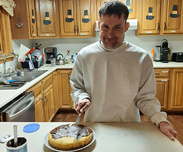 Young man frosting cake